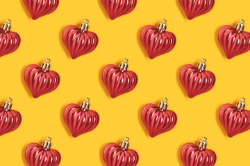 Pattern made of red New Year decorations on a yellow background. Creative festive concept.