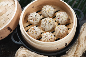 Close-up of a bamboo steamer with asian soup dumplings, selective focus, horizontal shot