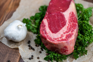 Raw marbled ribeye steak and spices