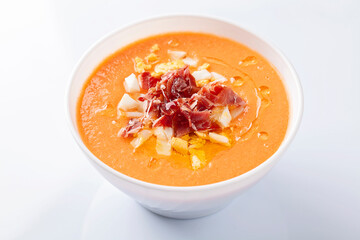 High angle view of a bowl of salmorejo soup on white background