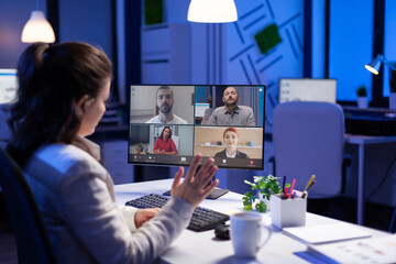 Manager during online video conference with corporate team after midnight using pc in start up...
