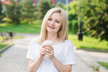 Portrait of a beautiful caucasian blonde woman with a cup of coffee. Femininity concept.