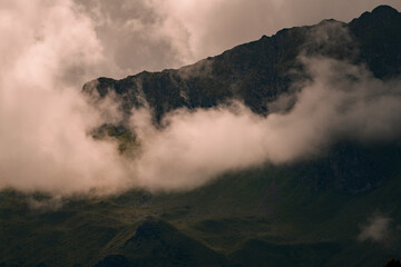 low hanging clouds in the mountains at a summer day