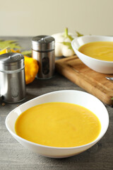 Concept of tasty food with pumpkin soup on gray textured table