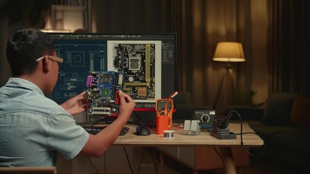 Asian Boy Is Working With Desktop Computer And Looking At Mainboard In Home, Display Showing Cad Software, Genius Children Concept
