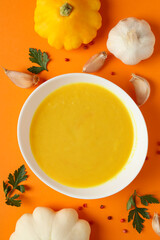 Concept of tasty food with pumpkin soup on orange background