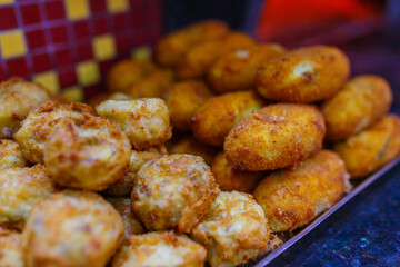 Frittatine di pasta fritte e crocchè di patate fritti tenuti in caldo vicino ad un forno a legna
