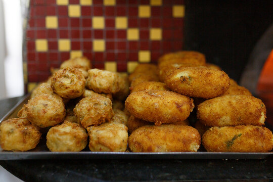 Frittatine di pasta fritte e crocch&egrave; di patate fritti tenuti in caldo vicino ad un forno a legna