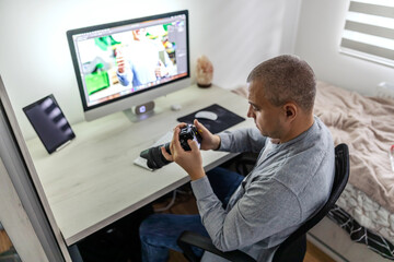 Homework corner. A close-up shot of a man employed in a media agency who controls and monitoring photos with the most modern camera Multimedia editing and improvement in home office by the male person