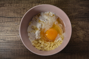 Raw ingredients for a one minute cake in a pink bowl