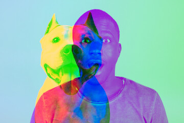 Portrait of young shocked man and silhouette of dog isolated over blue background with glitch...