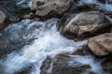 detail of a mountain river flowing between rocks, long exposure silk effect