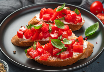 Bruschetta with tomato, basil and cream cheese close-up. Italian appetizer.