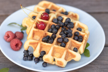 waffles Belgian mix of blueberries raspberries on a wooden background