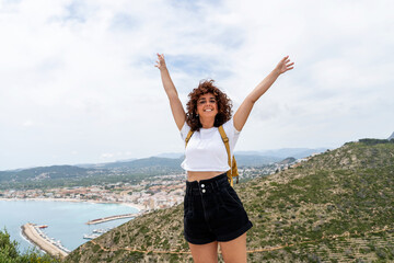 Horizontal view of woman on top of a mountain. Summer lifestyle. Happy woman with open arms.