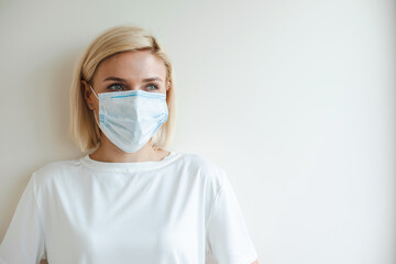 Blonde woman wearing medical mask. Coronavirus health problem. Virus protection. Pollution prevention. Health care.