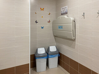 Public toilet for children. A washbasin, drawings on the walls, a changing table for babies.