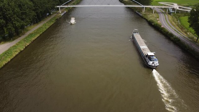 Pedestrian and cyclist bridge over the Amsterdams Rijn Canal,  waterway in Nigtevecht The Netherlands. Liniebrug. Big ship.