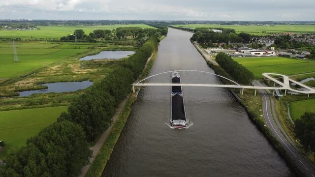 Pedestrian and cyclist bridge over the Amsterdams Rijn Canal,  waterway in Nigtevecht The Netherlands. Liniebrug. Big ship.