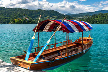 Naklejka na ściany i meble Woodden Boat on Lake Bled Emerald Green Water in Summer in Slovenia