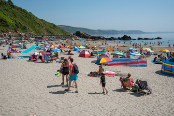 Fototapeta na wymiar Looe, Cornwall, England, UK. 2021. Holidaymakers sunbathing on the beach at East Looe a very popular resort in Cornwall, UK.