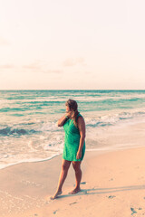 Fototapeta na wymiar Girl walks along the beach in a dress