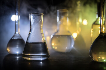 Test glass flask with solution in research laboratory. Science and medical background. Laboratory test tubes on dark toned background , science research equipment concept