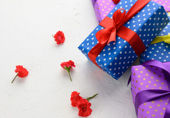 boxes packed in festive blue paper and tied with silk ribbon on white background, birthday gift, surprise