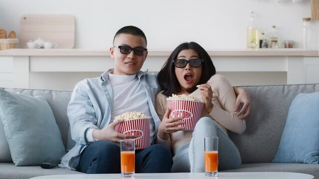 Amazed Japanese Couple Watching Film Wearing 3d Glasses At Home