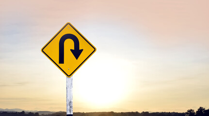 Right u-turn sign on pole, streetlights bokeh background. Concept for traffic sign at night.