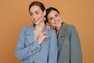 Two smiling elegant women wearing smart jackets