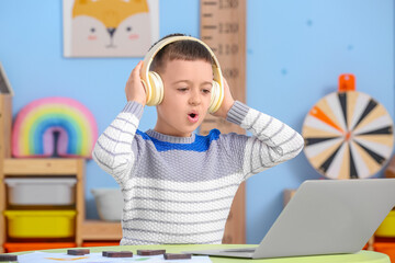 Little boy with laptop training pronounce letters at home