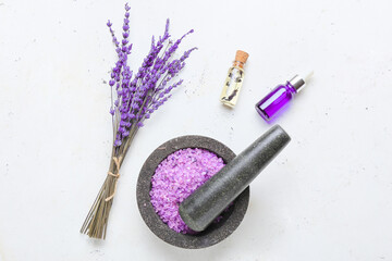 Composition with bottles of lavender essential oil, sea salt and flowers on light background