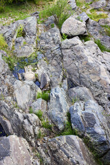 Mountain lava rock. Stone texture. Texture of mountain rock with grass