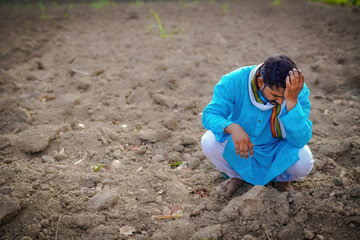 Indian poor farmer troubled by soil defect, sad farmer in the field