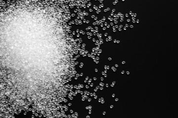 white granules of rubber and polypropylene on a black background. Plastics and polymers industry. Copy space