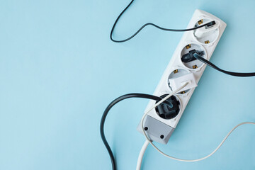 Electric white portable socket with connected devices on blue background