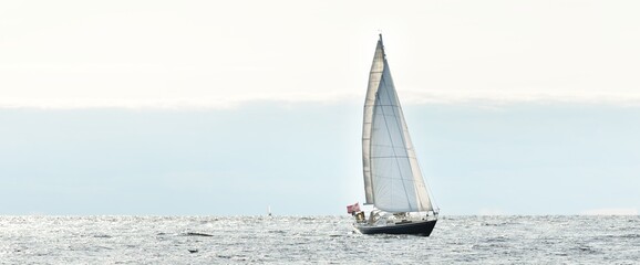 Blue sloop rigged yacht sailing in an open Baltic sea on a clear day, close-up. Riga bay, Latvia....