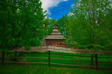brautiful landscape wood land outdoor place vivid green foliage and trees and wooden christian church in center of composition Eastern Europe country side environment space