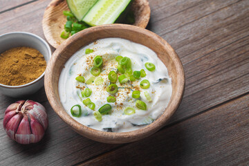 Traditional Indian Raita with Dahi in a bowl on a wooden table