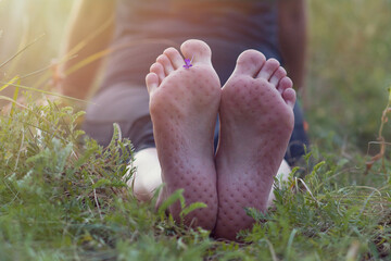 Bare feet on yoga with hobnail. Legs after meditation and spiritual practice lie on the grass in...