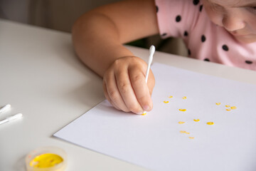 The concept of creative drawing. The child draws cotton buds.