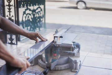 Man holding a piece of furniture that are cutting with an electric disc
