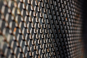 selective focus of dark metal mesh fence