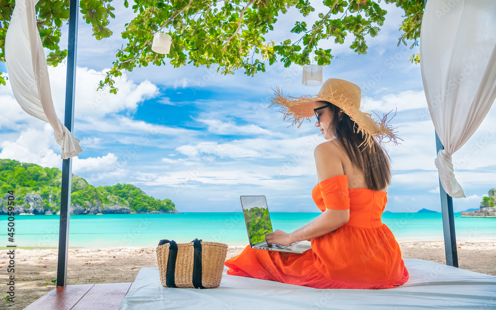 Wall mural Traveler Asian woman relaxing at sea beach using laptop, Businesswoman on vacation at private resort, Attraction place tourist travel Thailand summer holiday trip, Tourism beautiful destination Asia