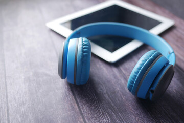 Obraz na płótnie Canvas Audio book concept. Headphones and digital tablet on table 