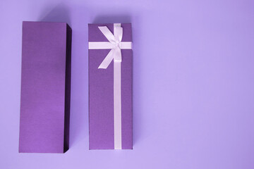 gift box with ribbon and greeting list on a purple background. Copy space for text. Selective focuse. Invitation card