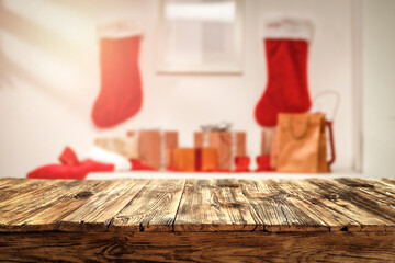 Wooden table in Christmas evening and background with gifts from Santa Claus 