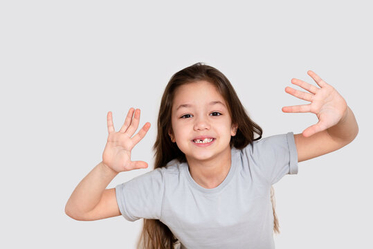 Portrait of a beautiful happy laughing child girl, close-up. Happy childhood concept, smiling. Little girl in white or grey blank t-shirts.The tooth is growing in the wrong place.