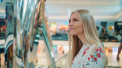 Amazed woman in shopping center. Young lady in elegant outfit admiring view in astonishment while...